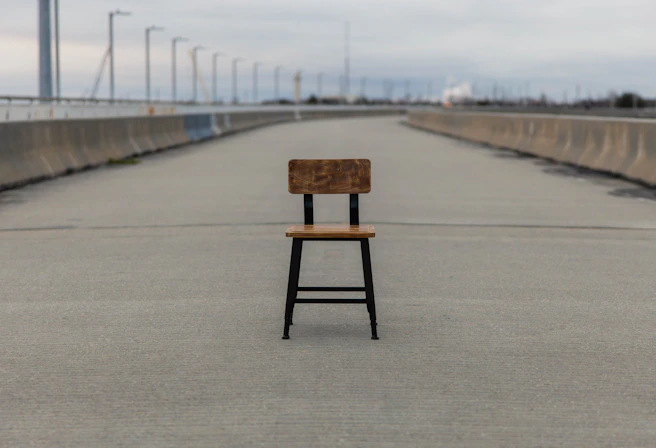 brown wooden seat on gray concrete road during daytime